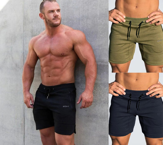 Man wearing black and green shorts with a gray background